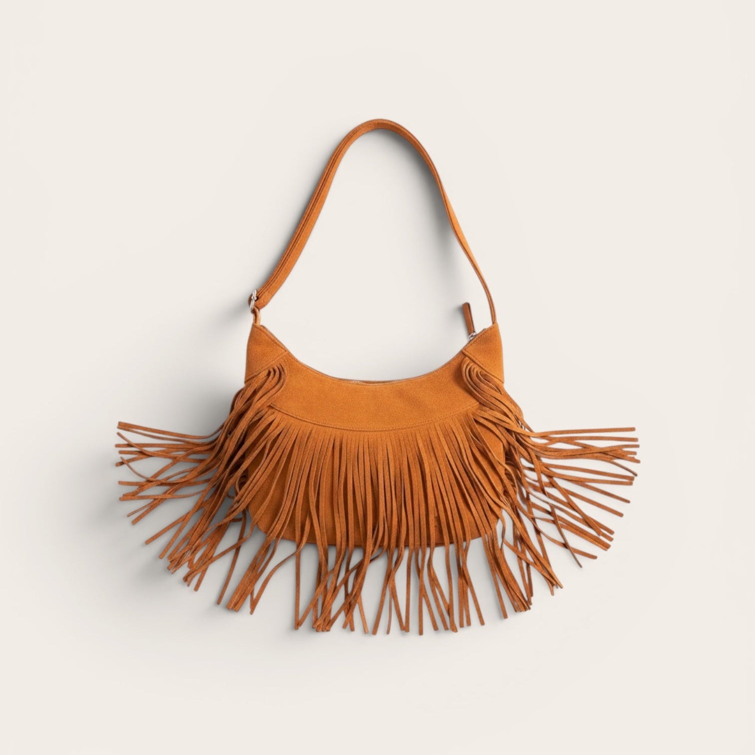 Brown suede handbag with fringe details on a light beige background